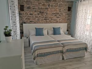 希洪Begoña 18 Rest & Adventure的一间卧室设有一张带砖墙的大床