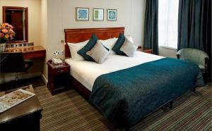 伦敦伦勃朗酒店的配有一张床和一张书桌的酒店客房