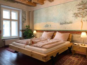 普日博尔Lucerna - dům s duší Příbor的卧室配有一张大床,墙上挂有绘画作品
