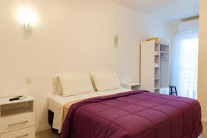 乌鲁比西Pousada das Flores UpSerra的一间卧室配有一张带紫色毯子的床