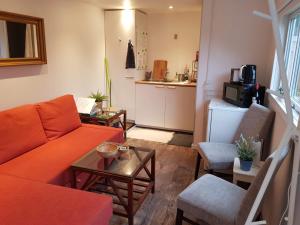 海莱乌Bonjour Copenhagen的客厅配有橙色沙发和桌子