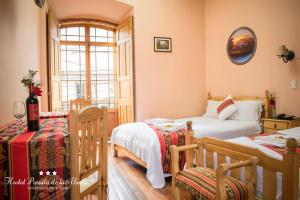 拉巴斯Hostal La Posada De La Abuela的一间卧室设有两张床和窗户。