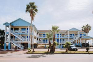 凯马Scottish Inn & Suites - Kemah Boardwalk的一座棕榈树环绕的大建筑