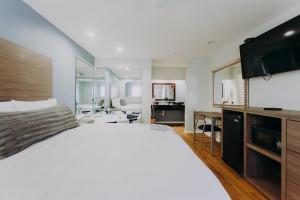 凯马Scottish Inn & Suites - Kemah Boardwalk的卧室配有一张白色大床和镜子