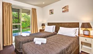 皇后镇皇后镇奥图蓝汽车旅馆的一间卧室设有两张床和窗户。