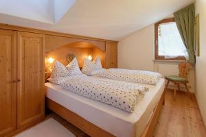多比亚科Residence Mairhofer的一间卧室配有一张大床和木制床头板