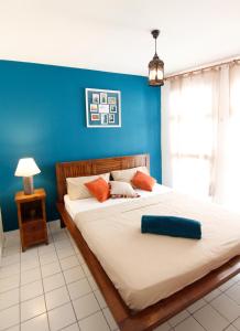 皮特尔角城Ocean View and Exclusive Flat Le croisieriste的一间卧室设有一张蓝色墙壁的大床