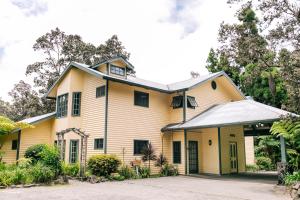 沃尔卡诺Kilauea Lodge and Restaurant的黄色和白色的屋顶房屋