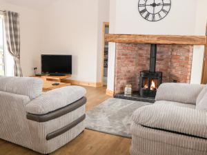 梅尔顿莫布雷Mandarin Cottage的客厅配有两把椅子和壁炉