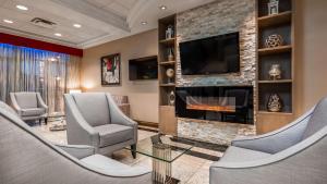 多伦多多伦多机场贝斯特韦斯特酒店的一间设有椅子和壁炉的等候室