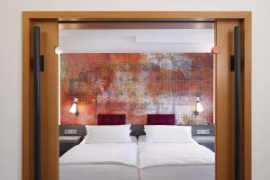 帕德博恩阿罗萨贝斯特韦斯特尊贵酒店的卧室内的两张床,墙上有绘画作品