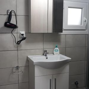 尼亚普拉莫斯Stathoris Deluxe Studio的一间带白色水槽和窗户的浴室