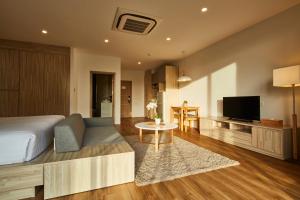 卡宾布里甲民武里宁静Spa酒店的一间卧室设有一张床,客厅设有电视。