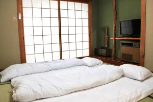 别府Beppu Kannawa Onsen HIROMIYA的窗户间内的床上的2个枕头