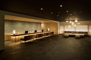 京都hotel kanra kyoto的一间设有长桌子和椅子的等候室
