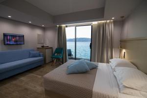 AiándionAianteion Bay Luxury Hotel & Suites的一间卧室配有一张大床和一张蓝色的沙发