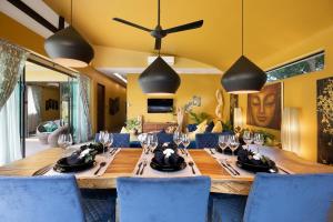 莱姆索塔Baan Putahracsa的用餐室配有长木桌子和蓝色椅子