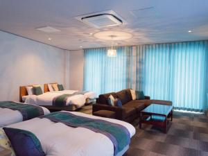 龙乡町卡乐达酒店的酒店客房,配有两张床和椅子