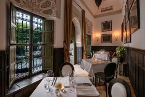 马拉喀什Le Farnatchi的餐厅设有桌椅和窗户。