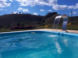 圣安娜-杜斯蒙蒂斯Pousada Chalés dos Montes的一个带喷泉的游泳池