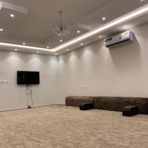 塔伊夫Al Taif Villas的一间配有沙发的房间和墙上的电视