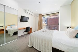 珀斯All Suites Perth的酒店客房设有一张床和一个阳台。