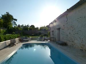 Courdimanche-sur-EssonnesCasa la Rosa & Spa的一座游泳池,毗邻一座带庭院的建筑