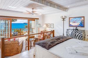 弗兰德希普Bequia Beach Hotel - Luxury Resort的一间卧室设有一张床和一个海景阳台