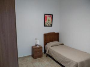 玛泽甘Apartamento para familias的一间卧室配有两张床、床头柜和图片