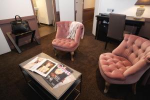 圣马洛拉迈松德斯阿玛托斯酒店的客厅配有两把椅子和一张桌子