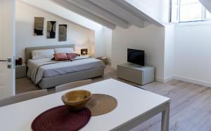 的里雅斯特Paduina3 Comfort Apartments的一间白色卧室,配有床和电视