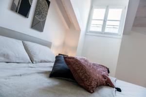的里雅斯特Paduina3 Comfort Apartments的一间卧室配有一张带枕头的床