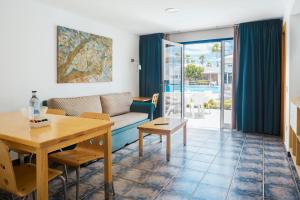 卡门港兰萨罗特鹦鹉螺公寓式酒店的客厅配有沙发和桌子