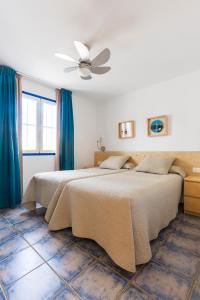 卡门港兰萨罗特鹦鹉螺公寓式酒店的一间卧室配有两张床和吊扇