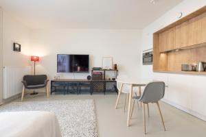 布鲁塞尔Mini loft with terrace的客厅配有桌椅和电视。