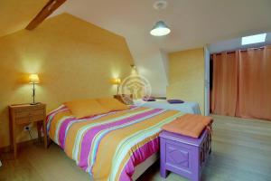 康庞La Boucle de l'Adour Chambres d'Hôtes & gîtes的一间卧室配有一张大床和色彩缤纷的毯子