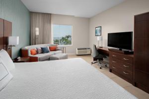 布里奇敦万豪巴巴多斯万怡酒店 的酒店客房配有一张床和一张书桌及一台电视