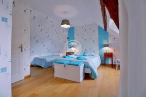 康庞La Boucle de l'Adour Chambres d'Hôtes & gîtes的一间卧室配有一张带蓝色床单和蓝色墙壁的床。