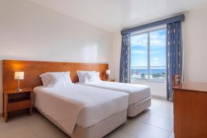 卡佩拉什Acorsonho Apartamentos Turisticos的一间卧室设有一张大床和一个大窗户