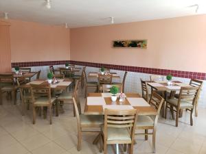 Sobradinho阿尔维马尔酒店的餐厅用餐室配有木桌和椅子