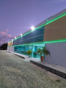 巴纳伊巴HOTEL CAJUÍNA BEACH的建筑的一侧有绿灯