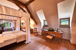 阿皮亚诺苏拉斯特拉达Schloss Englar的一间卧室配有一张天蓬床和一张书桌