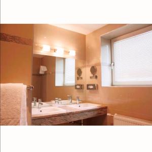 克拉根福阿拉基亚酒店的一间带两个盥洗盆和大镜子的浴室