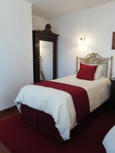 苏克雷苏默塞德埃尔旅馆的一间卧室配有一张带红色枕头的大床