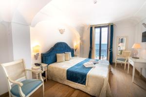 滨海波利尼亚诺萨拉森尼科沃酒店的卧室配有一张床和一张桌子及椅子
