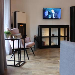 巴德塞尔佐根Wohnen am Solbad的客厅配有电视和桌椅