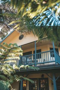 沃尔卡诺Kilauea Lodge and Restaurant的带阳台的房屋,带蓝色栏杆