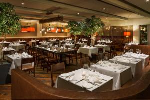 格林威治格林威治J公馆酒店的一间设有白色桌椅的用餐室