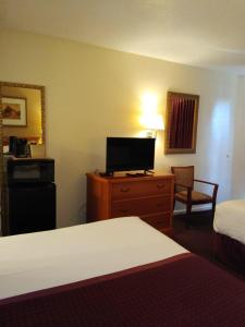 圣安东尼奥Knights Inn San Antonio near Frost Bank Center的酒店客房设有一间带一张床和电视的卧室