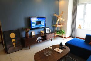 Xiazangtuan阅海民宿青岛北站海景公寓的客厅配有电视和蓝色的墙壁